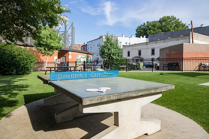 photo of Amp Park ping pong table on a sunny day with buildings and trees in the background