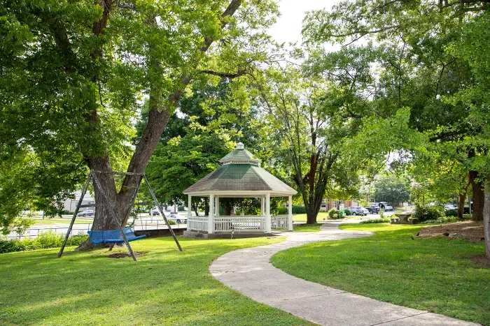 photo of smith park in the morning paved path leading to a gazebo surrounded by green trees